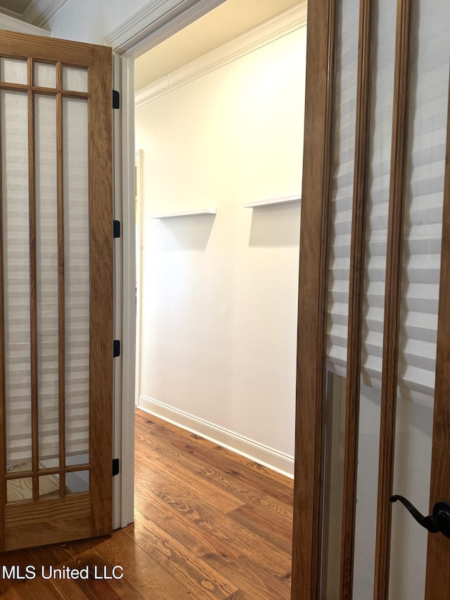 hallway with dark hardwood / wood-style floors and crown molding