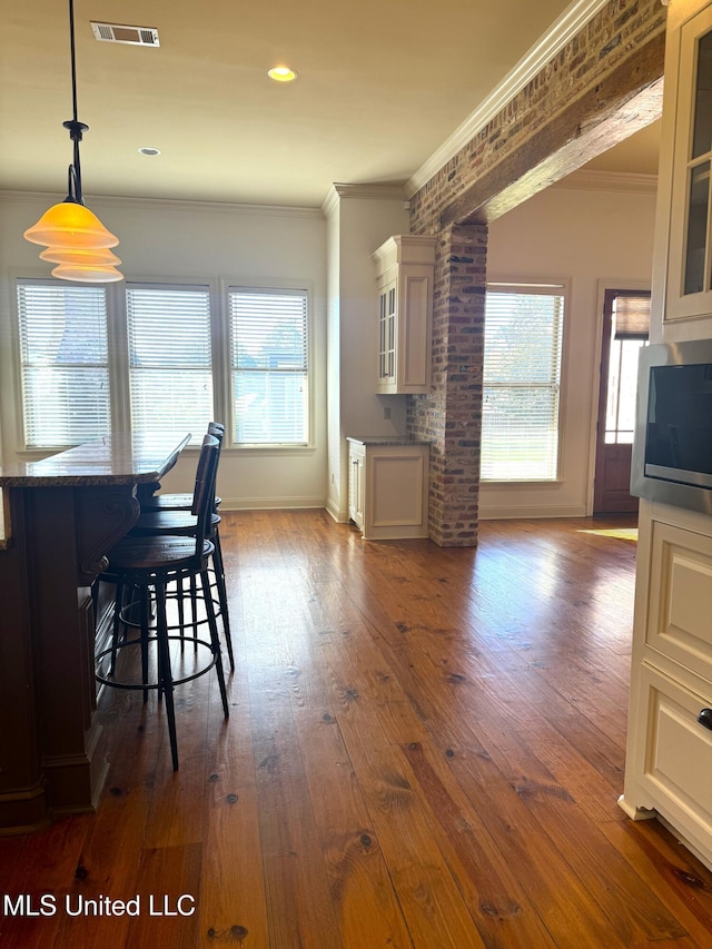 unfurnished dining area featuring dark hardwood / wood-style flooring and ornamental molding