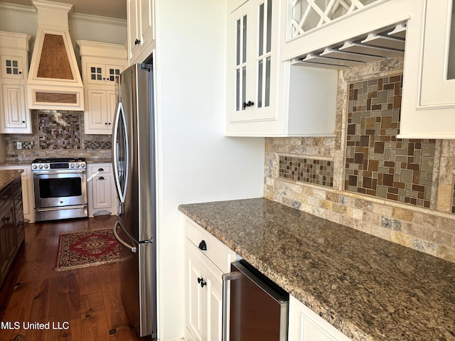 kitchen with stainless steel appliances, tasteful backsplash, dark stone counters, beverage cooler, and dark hardwood / wood-style flooring