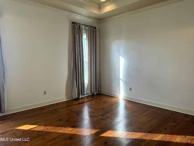 empty room with dark hardwood / wood-style flooring, a healthy amount of sunlight, crown molding, and a tray ceiling