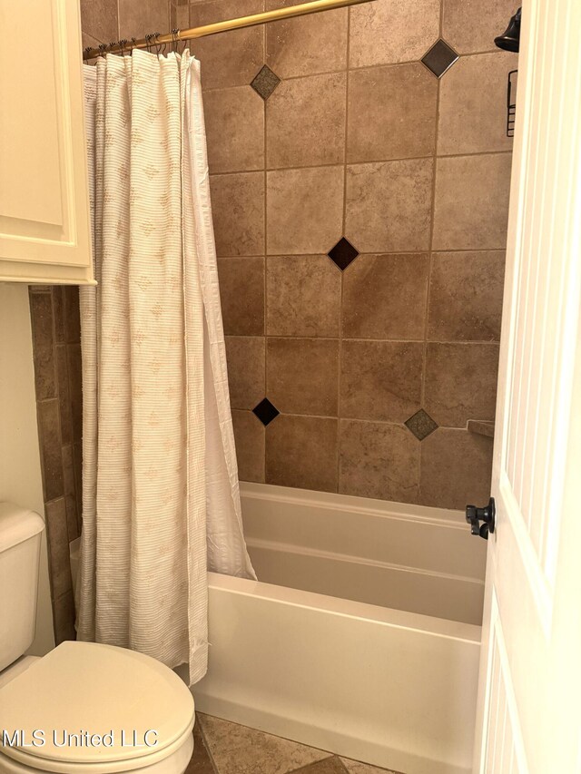 bathroom with tile patterned floors, toilet, and shower / tub combo with curtain