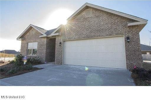 ranch-style home with a garage, concrete driveway, and brick siding