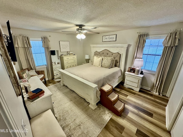 bedroom featuring multiple windows, wood finished floors, and visible vents