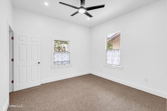 spare room with dark colored carpet, healthy amount of natural light, a ceiling fan, and recessed lighting