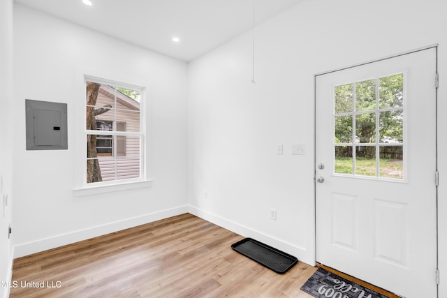 unfurnished dining area featuring electric panel, healthy amount of natural light, light wood-type flooring, baseboards, and recessed lighting