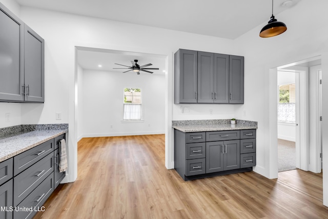 kitchen with gray cabinets, light wood finished floors, and healthy amount of natural light
