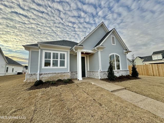 view of front of home with a lawn and central air condition unit