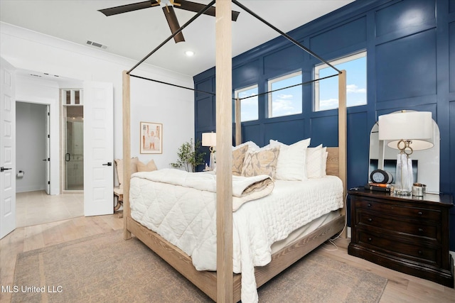 bedroom with hardwood / wood-style floors, connected bathroom, ceiling fan, and ornamental molding