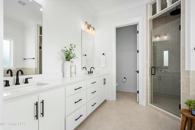 bathroom with tile patterned flooring, toilet, a shower with shower door, and crown molding