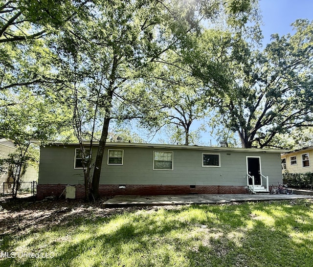 rear view of property featuring a lawn, fence, and entry steps