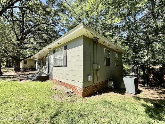view of side of property featuring crawl space and a lawn