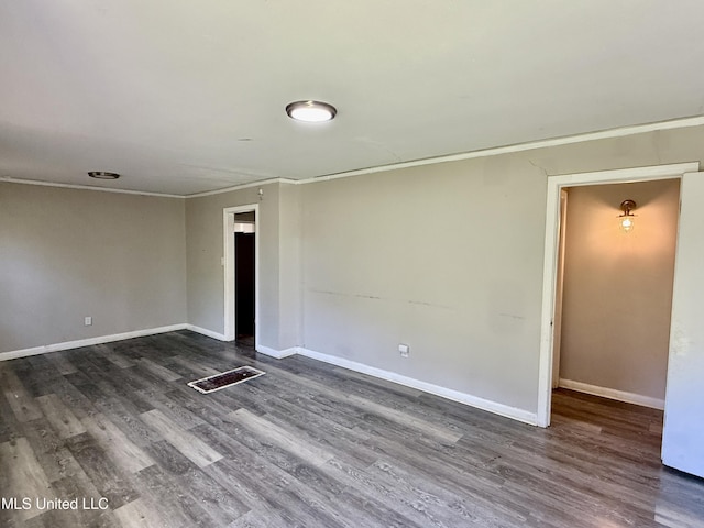 unfurnished room with baseboards, dark wood finished floors, and crown molding