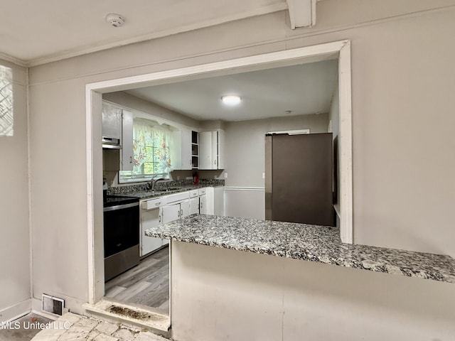 kitchen featuring a sink, freestanding refrigerator, open shelves, white cabinets, and light wood-style floors