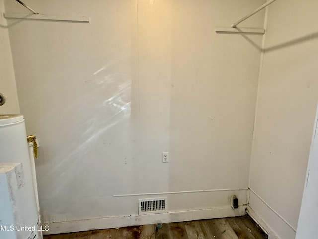 laundry room featuring laundry area, wood finished floors, visible vents, and gas water heater