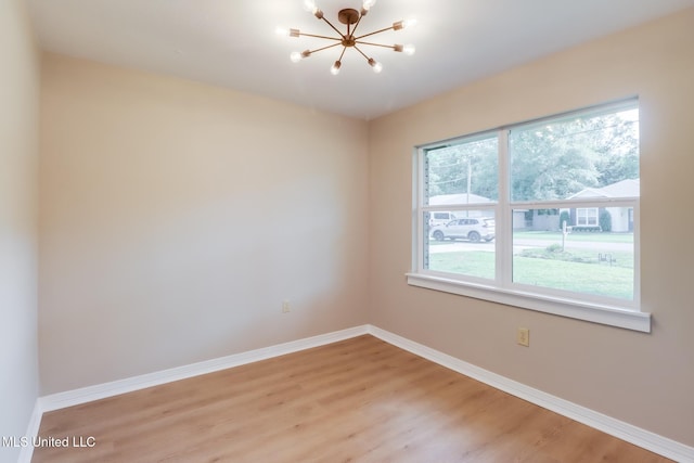 392 Lawler Ave, Long Beach, MS 39560 - spare room with a chandelier, light wood-style flooring, and baseboards