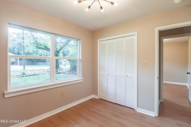 392 Lawler Ave, Long Beach, MS 39560 - unfurnished bedroom featuring multiple windows, light wood-style floors, baseboards, and a closet