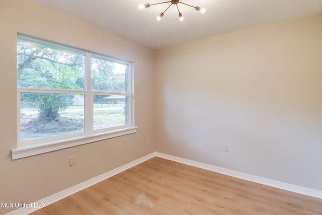 392 Lawler Ave, Long Beach, MS 39560 - empty room with a chandelier, plenty of natural light, baseboards, and light wood-style floors
