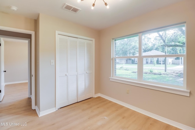 392 Lawler Ave, Long Beach, MS 39560 - unfurnished bedroom with light wood-type flooring, multiple windows, and baseboards