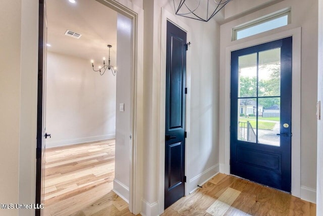 foyer entrance with an inviting chandelier and hardwood / wood-style floors