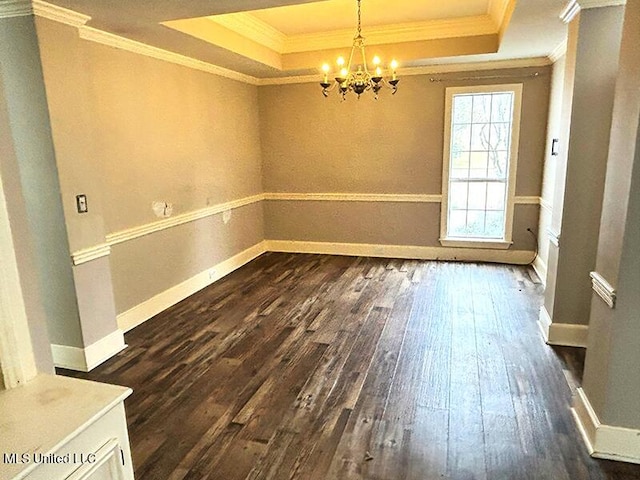 spare room featuring a tray ceiling, crown molding, a chandelier, and dark hardwood / wood-style floors