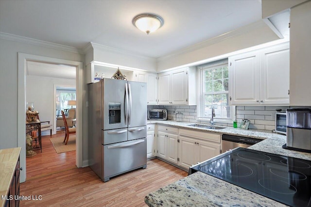 kitchen with stainless steel appliances, sink, light wood-type flooring, and white cabinets