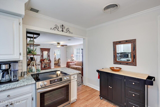 kitchen with ornamental molding, light hardwood / wood-style flooring, white cabinets, and stainless steel appliances