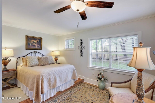 bedroom with ceiling fan, hardwood / wood-style flooring, and crown molding