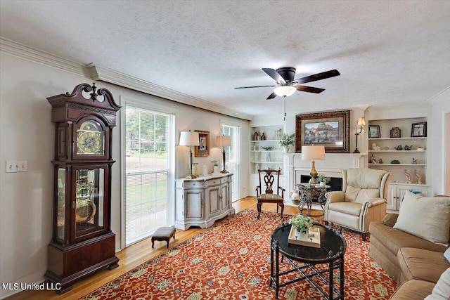 living room with crown molding, a textured ceiling, light wood-type flooring, and ceiling fan