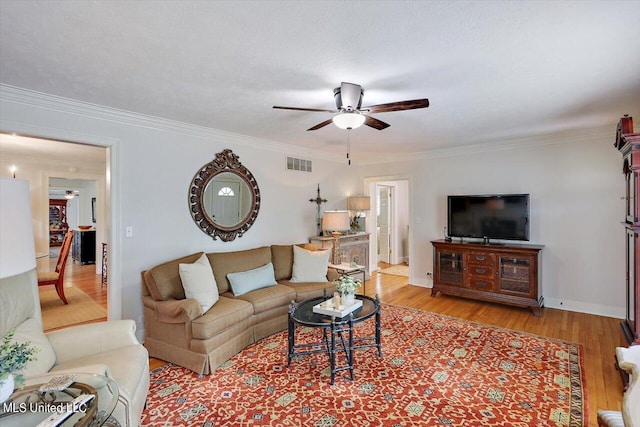 living room with light hardwood / wood-style floors, ornamental molding, a textured ceiling, and ceiling fan