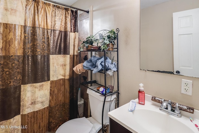 bathroom with walk in shower, vanity, and toilet