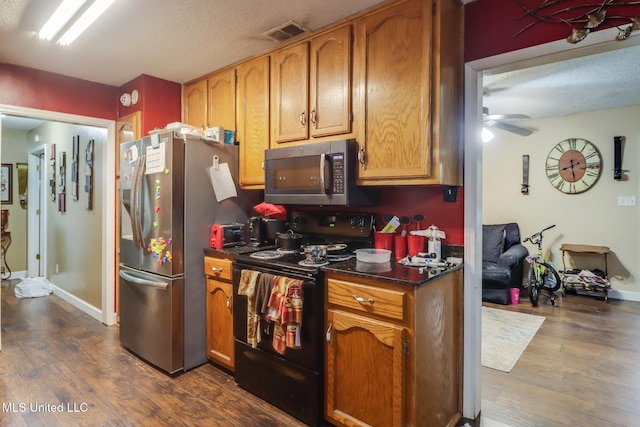 kitchen featuring stainless steel appliances, dark hardwood / wood-style floors, and ceiling fan