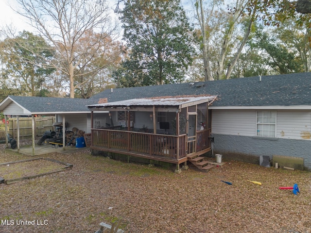 rear view of property with a sunroom and a deck