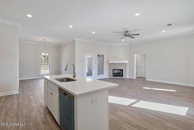 kitchen featuring sink, white cabinetry, decorative light fixtures, dishwasher, and a kitchen island with sink