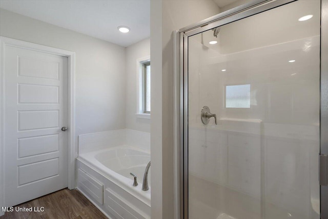 bathroom featuring wood-type flooring and separate shower and tub