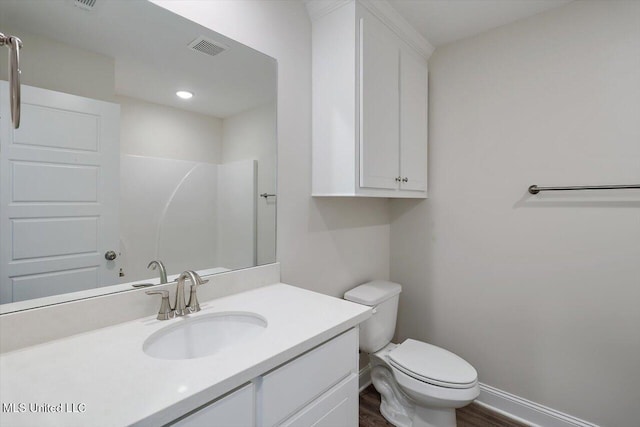 bathroom with walk in shower, vanity, toilet, and wood-type flooring