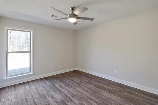 spare room featuring dark hardwood / wood-style floors and ceiling fan