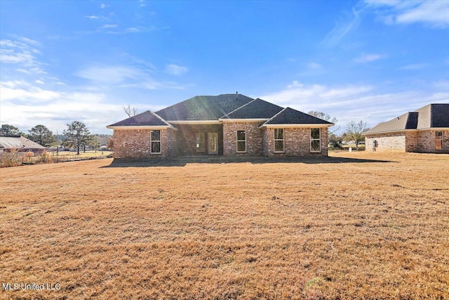 rear view of property with a yard