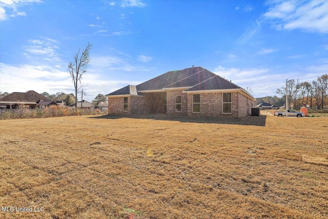 rear view of property featuring a lawn