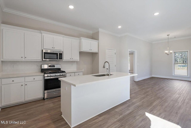 kitchen with white cabinets, appliances with stainless steel finishes, sink, and a kitchen island with sink