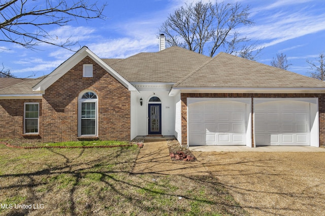 ranch-style home featuring brick siding, a chimney, an attached garage, a front yard, and driveway