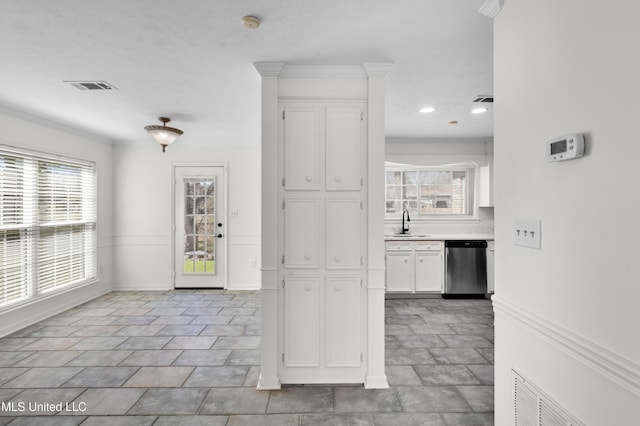 interior space with a sink, visible vents, white cabinetry, stainless steel dishwasher, and a wealth of natural light