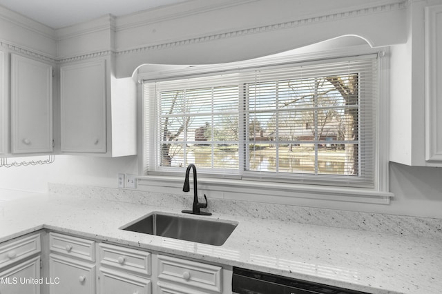 kitchen with dishwashing machine, a sink, light stone countertops, and white cabinets