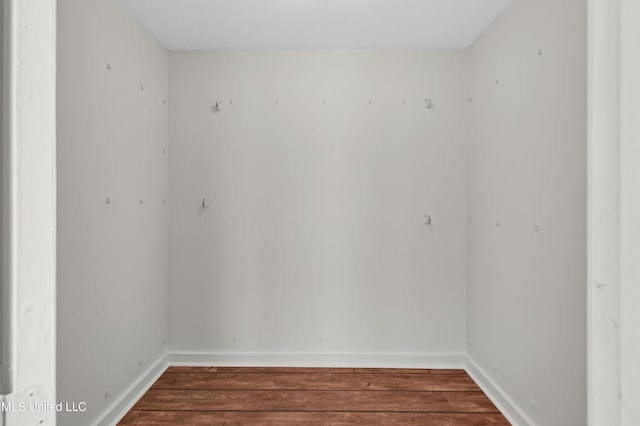 spare room featuring baseboards and wood finished floors