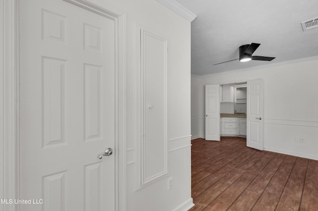 corridor with baseboards, visible vents, dark wood-type flooring, and crown molding