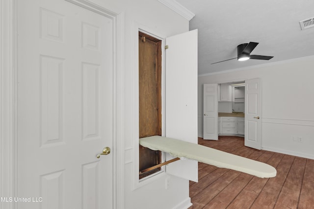 corridor with hardwood / wood-style flooring, visible vents, and crown molding