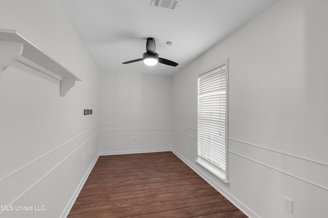 spare room featuring dark wood-style flooring, visible vents, plenty of natural light, and ceiling fan