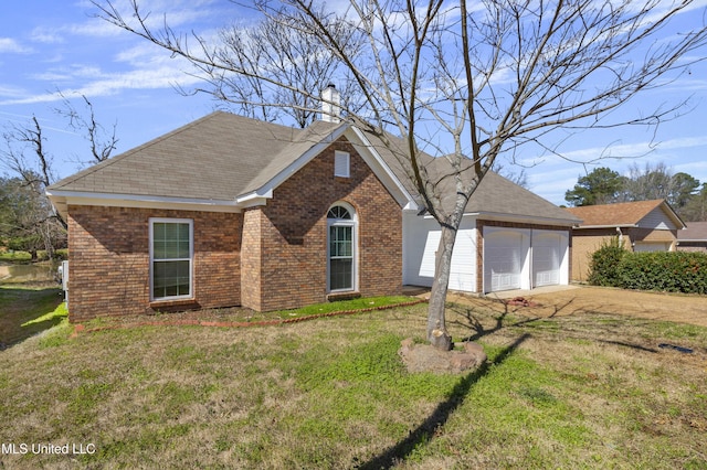 ranch-style house featuring brick siding, an attached garage, a chimney, and a front lawn