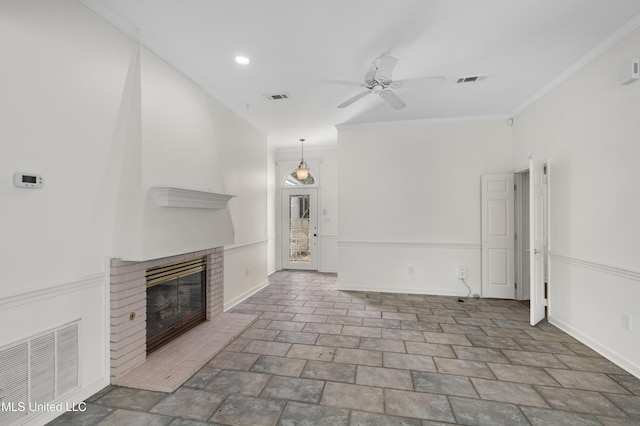 unfurnished living room featuring ornamental molding, a fireplace, visible vents, and baseboards