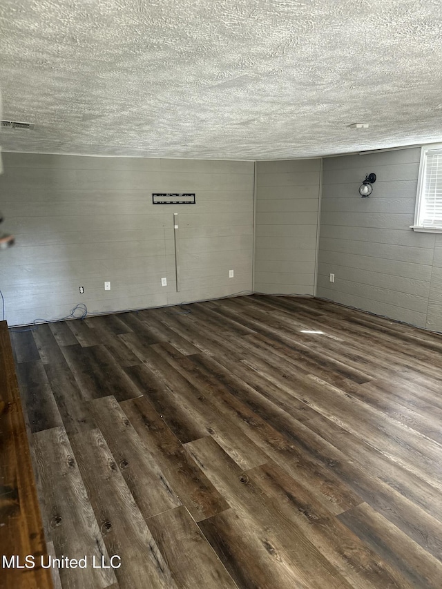203 Barrow St, Pearl, MS 39208 - unfurnished living room featuring wood finished floors, a textured ceiling, and wood walls