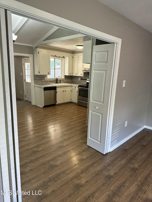 203 Barrow St, Pearl, MS 39208 - kitchen with appliances with stainless steel finishes, ornamental molding, light countertops, dark wood-type flooring, and white cabinets